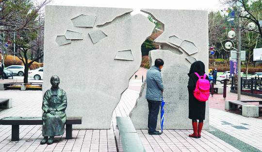 경기도 수원시 ‘나혜석거리’에 자리한 나혜석 기념벽과 좌상. ‘역사여행’을 다니는 순례자들이 기념벽의 글을 읽고 있다. 나혜석 생가터는 이곳에서 3.5㎞ 지점 수원종로교회 앞이다.