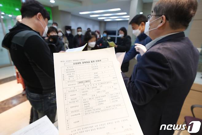26일 오전 6시 대구 북구 침산동 소상공인시장진흥공단 대구북부센터에서 공단 관계자가 신종 코로나바이러스 감염증(코로나19) 정책자금 융자를 신청하기 위해 이른 아침부터 이곳을 찾는 소상공인에게 신청 방법을 설명하고 있다. 2020.3.26/뉴스1 © News1 공정식 기자