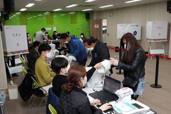 제21대 국회의원선거 사전투표 첫날인 10일 오전 광주 광산구 어룡동 행정복지센터에 설치된 사전투표소에서 코로나19 예방을 위해 마스크를 착용한 투표사무원이 유권자를 안내하고 있다. 연합뉴스
