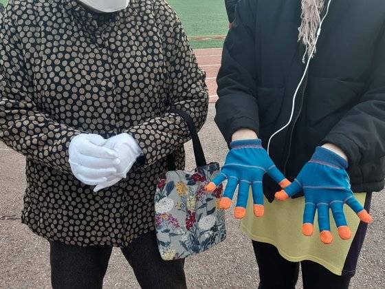 15일 오전 유권자들이 집에서 가지고 온 장갑을 보여주고 있다. 함민정 기자
