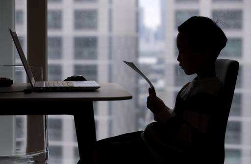 20일 오전 서울 용산구의 한 가정에서 용산초등학교 1학년에 입학한 신입생 어린이가 노트북 앞에서 학교 유인물을 바라보며 입학식을 하고 있다. 연합뉴스