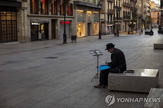 스페인 바르셀로나의 텅 빈 거리에 앉아있는 악사 [AP=연합뉴스]