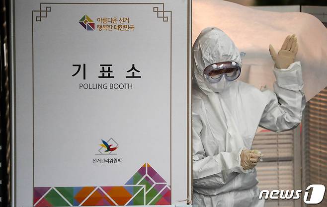 제21대 국회의원 선거 투표일인 15일 서울 가회동 주민센터행정복지센터에 마련된 신종 코로나바이러스 감염증(코로나19) 자가격리자 투표소에서 방호복을 입은 선관위 관계자가 기표소 안을 소독하고 있다. 2020.4.15/뉴스1 © News1 허경 기자