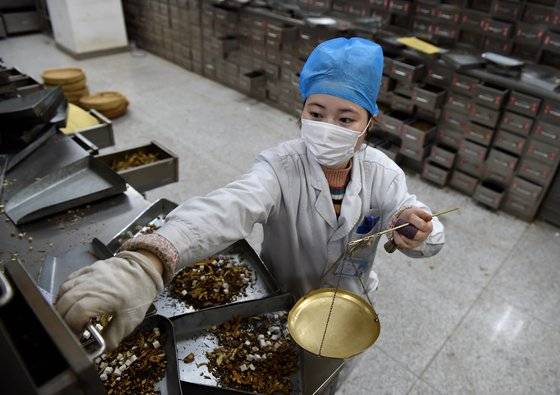 지난 2월 24일 중국 안후이성의 한 대학병원에서 마스크를 낀 약제사가 한약을 조제하고 있다. 중국 정부는 중의약으로 코로나19 치료에 효과를 봤다고 주장하고 있다. [신화=연합뉴스]