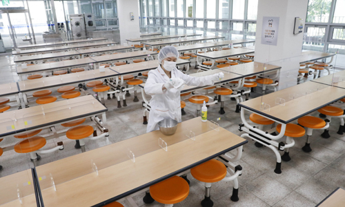 지난 4일 오후 서울 강서구 공항고등학교에서 영양사 선생님이 신종 코로나바이러스 감염증(코로나19) 예방을 위해 유리 칸막이를 설치한 급식실을 청소하고 있다. 뉴시스