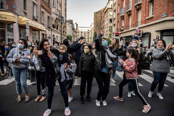 파리 동쪽 교외도시 생망데에서 11일 저녁 8시가 되자 시민들이 거리로 몰려나와 의료진을 격려하는 박수를 치고 있다/AFP 연합뉴스