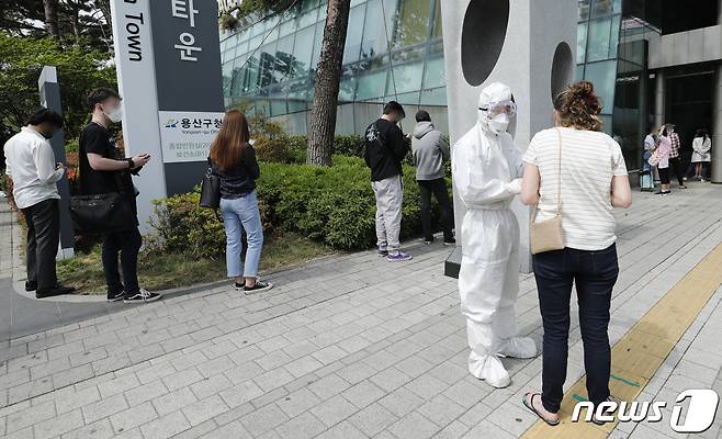 서울 용산구 보건소에 마련된 선별진료소에서 관계자가 외국인을 안내하고 있다/뉴스1 © News1 안은나 기자