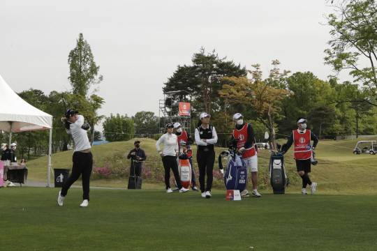 마스크 쓴 캐디들 : 박지영(왼쪽)이 14일 오전 경기 양주시의 레이크우드 컨트리클럽 산길·숲길코스에서 열린 KLPGA 챔피언십 1라운드에서 10번 홀 티샷을 하고 있다. 선수들은 샷을 할 때 마스크를 잠시 벗었고 캐디들은 마스크를 착용하고 있다.   AP연합뉴스