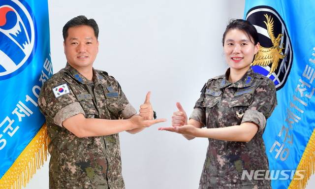 [서울=뉴시스] 서종철·김미정 중령이 '덕분에 챌린지' 수어 동작을 함께 하며 기념촬영을 하고 있다. 2020.05.20. (사진=공군 제공)