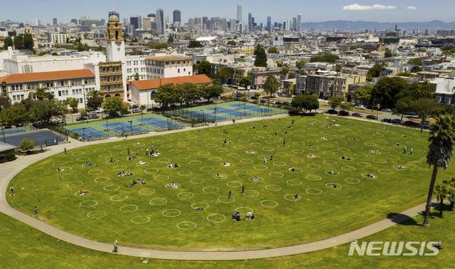 [샌프란시스코=AP/뉴시스] 21일(현지시간) 미국 샌프란시스코 돌로레스 파크를 찾은 시민들이 신종 코로나바이러스 감염증(코로나19) 예방을 위해 그려진 원 안에서 휴식을 취하고 있다. 202005.22.