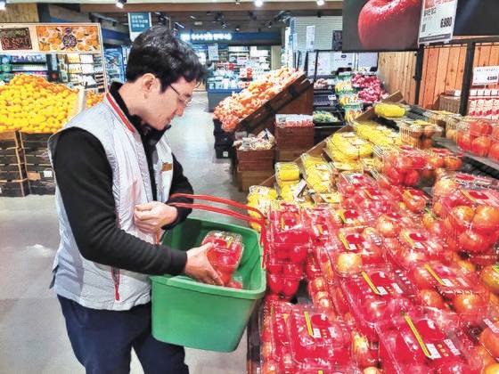 고객이 애플리케이션으로 주문한 토마토를 롯데마트 관계자가 담고 있다. 문희철 기자.