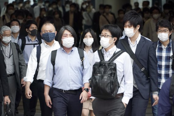 긴급사태가 전면 해제된 직후인 26일 오전 도쿄의 출근길 풍경. 마스크를 쓴 출근 인파가 역을 빠져나가고 있다. AP뉴시스