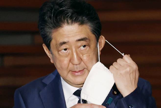 마스크를 벗는 아베 신조 일본 총리 [AP]