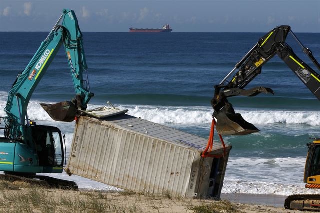 사우스웨일스주 뉴캐슬의 본다이비치에서 28일 관계자들이 중장비를 이용해 해안가로 밀려온 컨테이너 잔해를 수습하고 있다. 시드니=EPA 연합뉴스