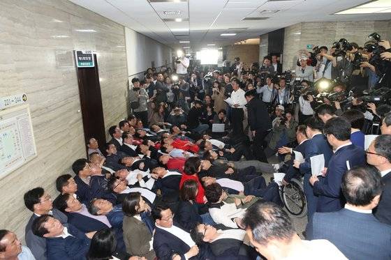 지난해 4월 26일 나경원 원내대표 등 자유한국당 의원들이 사법개혁특위가 열리는 국회 회의실 앞에 드러누워 이상민 위원장 등 참석자 진입을 막는 모습. [연합뉴스]
