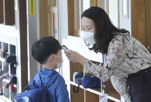 초등학교 저학년 등교 첫 날인 지난 27일 오전 충북 청주시 흥덕구 솔밭초등학교에서 학생들이 교실로 들어가기 전 발열 체크를 하고 있다. 뉴스1