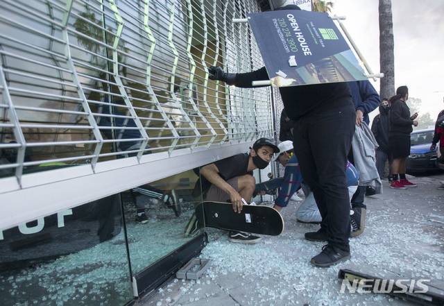 [로스앤젤레스=AP/뉴시스]5월30일(현지시간) 미국 캘리포니아주 로스앤젤레스에서 일부 시위대가 상점에 무단 침입해 물건을 훔치고 있다. 미국에서는 백인 경찰에게 목이 짓눌려 사망한 흑인 조지 플로이드 사건을 규탄하는 시위가 격렬해지고 있다. 2020.06.01.