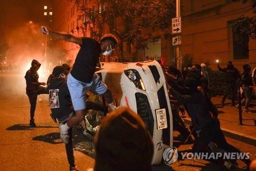 백악관 인근에서 차량 부수는 '흑인사망' 항의 시위대 (워싱턴 AP=연합뉴스) 미국 백인 경찰의 가혹 행위로 흑인 남성 조지 플로이드가 사망한 사건에 분노한 시위대가 지난달 31일(현지시간) 수도 워싱턴DC 백악관 인근에서 차량을 부수고 있다.