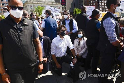 쥐스탱 트뤼도 캐나다 총리가 5일(현지시간) 캐나다 오타와에서 열린 인종차별 반대 시위에 깜짝 참여해 무릎 꿇기를 하는 모습.  [AP=연합뉴스]