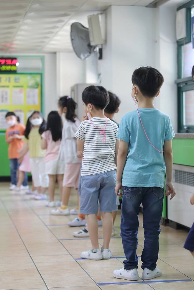 "이제 거리 두기는 일상" (광주=연합뉴스) 천정인 기자 = 8일 오후 광주 서구 운천초등학교에서 학생들이 점심 배식을 받기 위해 거리 두기를 하며 줄을 서 있다. 2020.6.8    iny@yna.co.kr