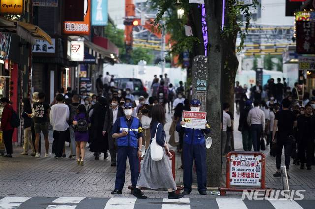 [도쿄=AP/뉴시스]도쿄도 직원들이 지난 4일 신주쿠 가부키초 유흥가에서 호객행위 금지를 알리는 플래카드를 들고 있다. 도쿄도는 지난 2일 신종 코로나바이러스 감염증(코로나19) 감염자가 증가하자 자체적인 경고 조치인 도쿄 얼러트를 발동했다. 정부의 긴급사태 발령이 해제된 지 일주일 만이었다. 2020.06.09.