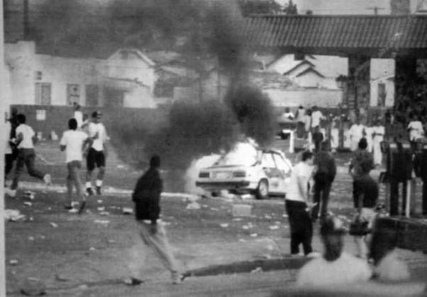 흑인 로드니 킹 구타 사건에 대한 평결이 난 직후인 1992년 4월 29일(현지시간) 폭동이 일어난 LA 남부 중심가에서 폭도와 구경꾼들이 불타는 자동차 주위에 모여있다. 연합뉴스