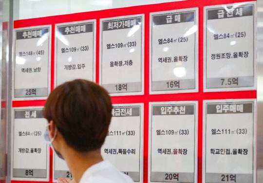 한 시민이 잠실동의 한 부동산 중개업소에 걸린 아파트 매매 및 전·월세 정보를 살펴보고 있다.<연합뉴스>