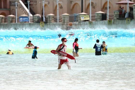 무더위에 워터파크를 찾은 피서객들의 모습. 코로나19의 여파로 '물 반 사람 반'이던 예년의 풍경은 사라졌다. 마스크를 착용한 안전 요원의 모습도 아직은 낯설다. [사진 에버랜드]