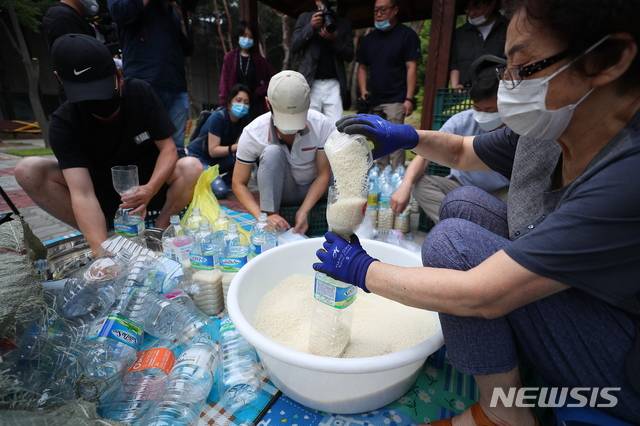 [서울=뉴시스] 전신 기자 = 탈북단체 '큰샘' 회원들이 18일 오전 서울 강남구 일원동에서 북한에 보낼 쌀을 페트병에 담고 있다. 이들은 오는 21일 강화 석모도에서 페트병에 쌀과 마스크를 담아 북한에 보낼 예정이다. 2020.06.18. photo1006@newsis.com