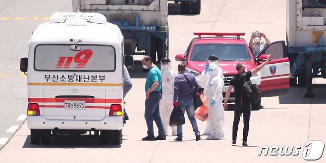 23일 오후 부산 감천항에 정박한 러시아 국적 냉동화물선에서 코로나19 양성 판정을 받은 선원들이 부산의료원으로 이송되고 있다. 이 화물선 선원 21명 중 16명이 코로나19 양성판정을 받았다/뉴스1 © News1 여주연 기자