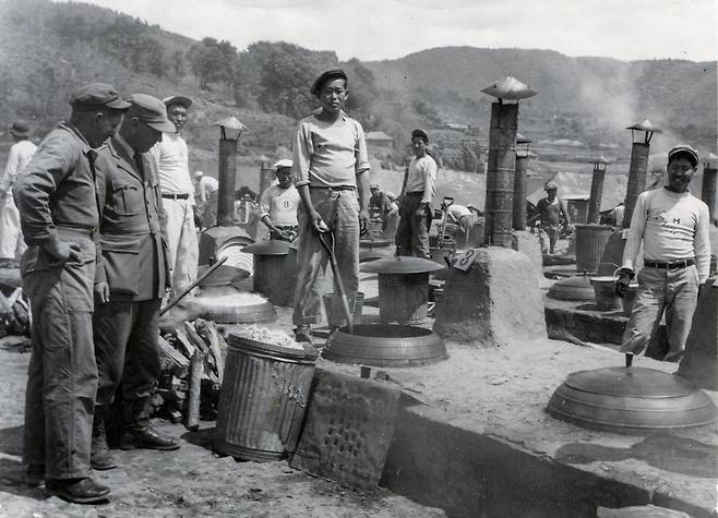 포로수용소에서 식사 준비 중인 요리사들 (서울=연합뉴스) 한국전쟁 70주년을 맞아 국제적십자위원회(ICRC)가 보유하고 있던 한국전쟁 당시 모습이 담긴 사진을 연합뉴스가 입수했다. 이 사진들은 한국전 당시 한반도에 파견됐던 ICRC 관계자들이 기록했던 것으로 전쟁 포로와 참상 등의 모습이 담겨 있다. ICRC는 한국전쟁의 시작과 동시에 한반도에 파견돼 유엔군과 공산군 간 제네바 협약 준수 감시 활동과 난민 구호 활동 등을 했다. 사진은 1951년 6월4일 거제 전쟁포로 캠프에서 요리사들이 수감자들을 위해 음식을 준비하는 모습. [국제적십자위원회(ICRC) 제공. 재판매 및 DB 금지]