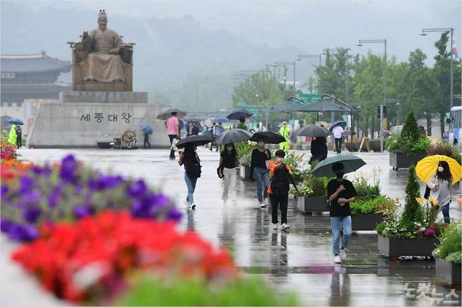 본격적인 장마가 시작된 24일 서울 광화문광장에서 시민들이 우산을 쓴 채 발걸음을 재촉하고 있다. 황진환기자