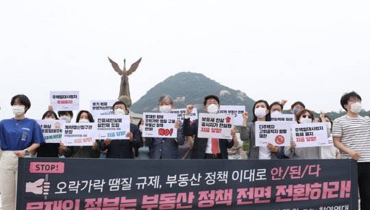 참여연대 회원들이 29일 청와대 분수대광장에서 '문재인 정부 부동산 정책 전면 전환 촉구' 기자회견을 열고 보유세 실효세율의 획기적인 강화와 공시가격 현실화. 다주택자 양도소득세 강화 등 투기 규제와 서민 주거 안정을 위한 7대 요구안을 발표한 뒤 구호를 외치고 있다.<연합뉴스>