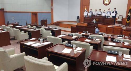 국회 닮아가는 지방의회 (강릉=연합뉴스) 이해용 기자 = 1일 강원 강릉시의회에서 민주당 소속 시의원들이 사전 협의 없이 원 구성을 하려고 한다며 의장석에 올라가 항의하고 있다. 통합당과 통합당 복당을 추진하는 무소속 의원들은 자리를 떴다. 2020.7.1