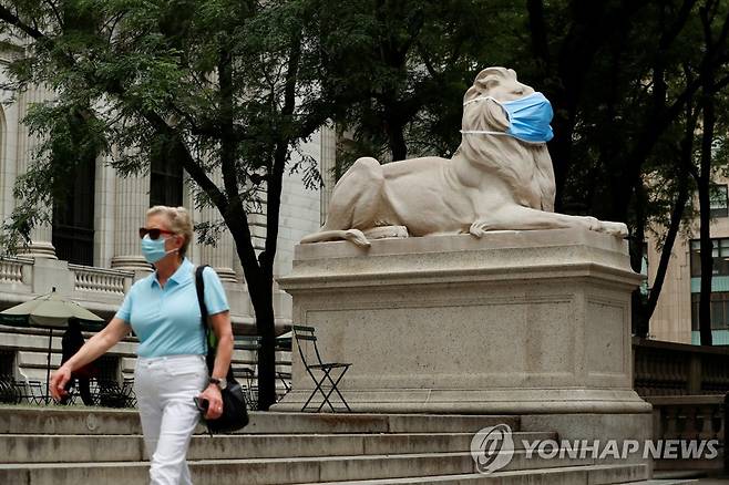 미국 뉴욕 공립도서관 앞 대형 마스크를 쓴 사자상과 마스크를 착용하고 그 앞을 지나는 행인 [로이터=연합뉴스]