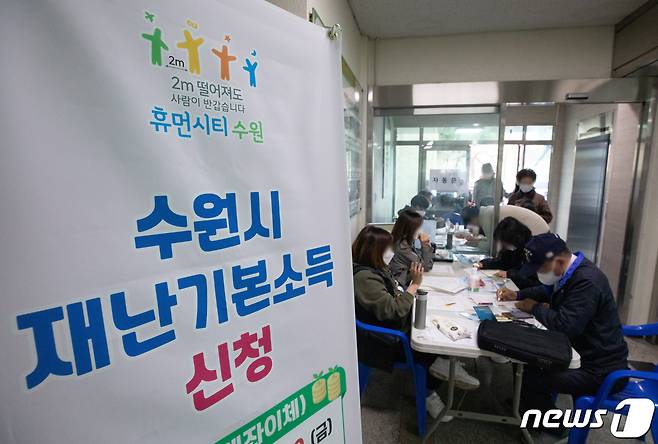 재난기본소득 현장접수일인 21일 오후 경기도 수원시 권선구 세류2동 행정복지센터를 찾은 시민들이 줄을 서 있다. 2020.4.21/뉴스1 © News1 이재명 기자