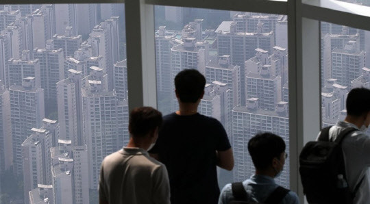 시민들이 서울 롯데월드타워 서울스카이에서 서울 송파구 한강변 아파트 단지를 바라보고 있다.<연합뉴스>