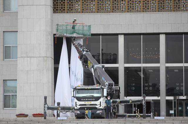 제21대 국회가 임기가 시작한지 한달이 지나도록 개원식조차 열지 못한 가운데 지난1일 국회의사당 현관에 걸렸던 '제21대 국회 개원 축하' 현수막이 철거되고 있다. 연합뉴스