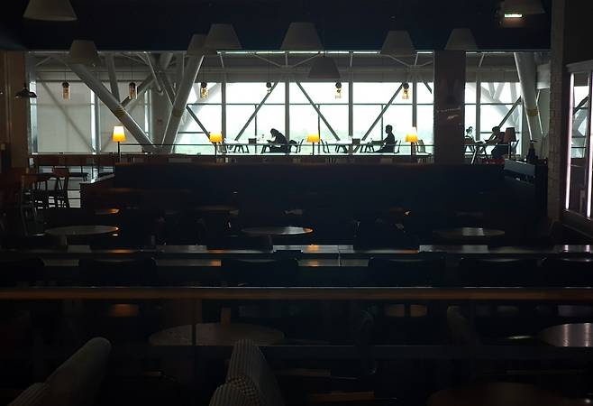 텅 빈 국제선 청사 테이블에서 공부하는 청년들. 앞쪽 커피숍은 불이 꺼져 있다. [손형주 기자]