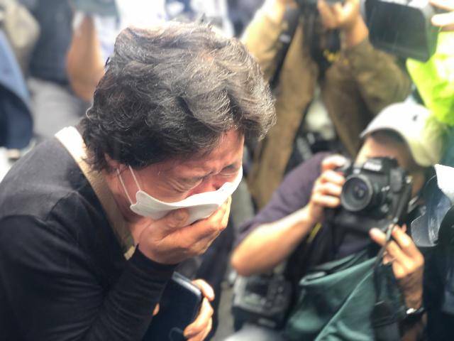 13일 오전 서울시청에서 고 박원순 서울시장의 영결식이 끝난 뒤 박 시장의 영정이 운구차에 옮겨 타자 한 시민이 눈물을 흘리고 있다. 이승엽 기자