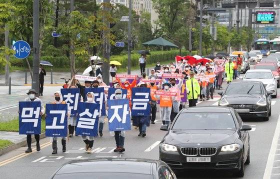 제8차 최저임금위원회 전원회의가 열리고 있는 13일 오후 민주노총 관계자들이 세종시 정부세종청사 인근 도로에서 '최저임금 인상 쟁취, 사용자 삭감안 즉각 폐기'를 촉구하며 행진하고 있다. 연합뉴스.