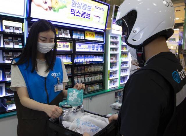 GS25 매장에서 직원이 배송기사에게 전달 전 아이스크림 배송을 위해 GS25가 자체 개발한 보냉백에 친환경 아이스팩을 넣고 있다./사진제공=GS25