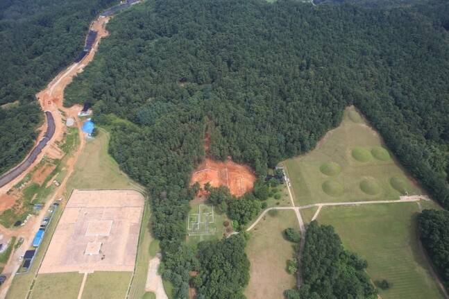 하늘에서 본 능산리 고분군. 아래쪽으로 돌출된 숲 한가운데 누런 땅 드러난 부분이 서고분군의 8, 10호분 발굴지점이다. 숲 오른쪽의 잔디밭 봉분들이 사적 지정된 기존 능산리 고분군이다. 숲 왼쪽의 허옇고 큰 건물터는 1993년 금동대향로가 나온 능사 터다. 사진 한국전통문화대 고고학연구소 제공