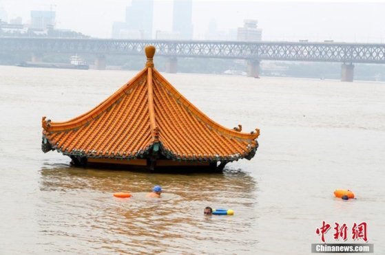 10일 후베이성 우한시 시민들이 홍수로 불어난 양쯔강에서 헤엄치고 있다. [중신망 캡처]