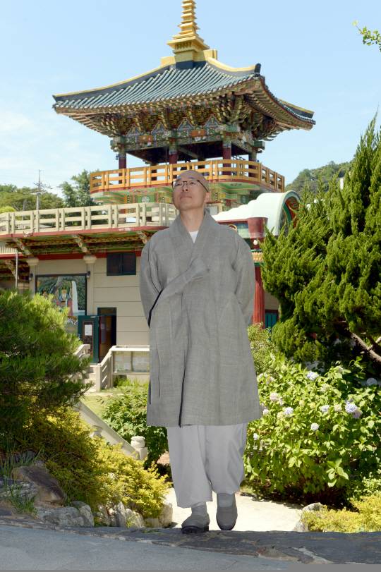 법상 스님이 지난 14일 부산 수영구 금련사 경내를 걸으면서 멀리 하늘을 보고 명상을 하고 있다. 스님은 생각을 잠시 멈추는 명상은 설거지, 청소, 보행 중에도 할 수 있다고 말했다. 김호웅 기자