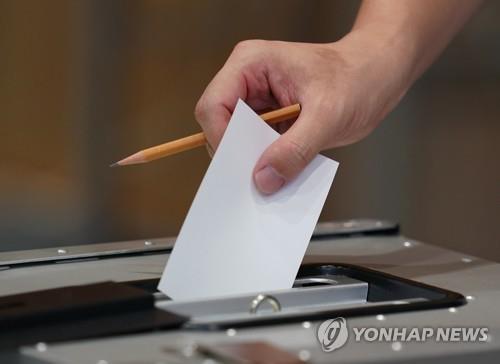 (도쿄 EPA=연합뉴스) 2020년 7월 5일 일본 도쿄에 설치된 도쿄지사 선거 투표소에서 유권자가 투표용지를 투표함에 넣고 있다.