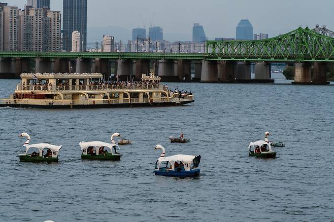 해 질 녘 한강 파라다이스 건물 전망대에서 바라본 풍경. 한강유람선이 한강철교를 향해 가고 있다. 오리배는 한강 파라다이스 건물에서 탈 수 있다. 이하 서울관광재단 제공