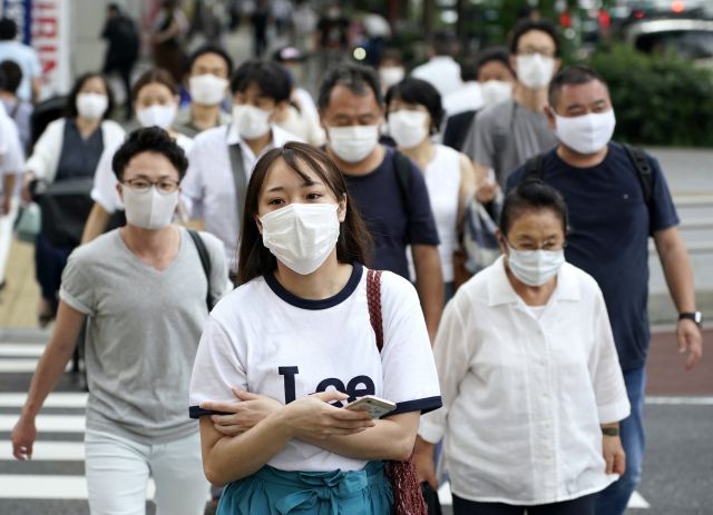 일본 도쿄 신주쿠에서 22일(현지시간) 마스크를 쓴 시민들이 걸어가고 있다. EPA 연합뉴스