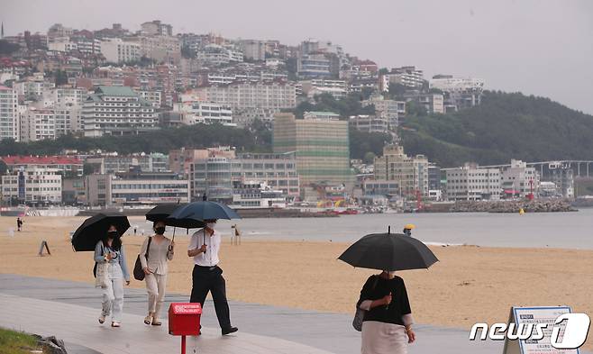 부산 해운대구 해수욕장을 찾은 시민들이 우산을 쓰고 백사장을 걷고 있다. 2020.6.18/뉴스1 © News1 여주연 기자