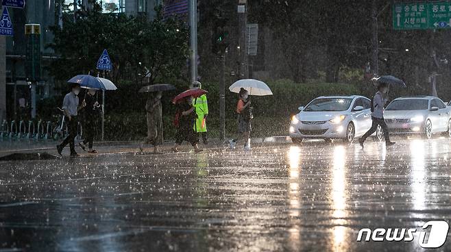 서울 전역에 호우주의보가 발령된 23일 오후 서울 세종대로 광화문광장 인근에서 시민들이 우산을 쓰고 발걸음을 재촉하고 있다. 2020.7.23/뉴스1 © News1 이승배 기자